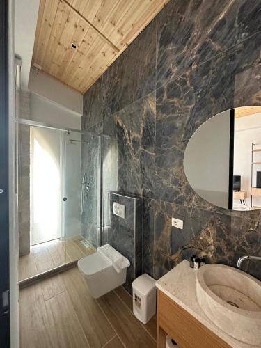 a bathroom with a sink and a toilet and a mirror at Trevi Hotel & Restorant, Shengjin in Shëngjin