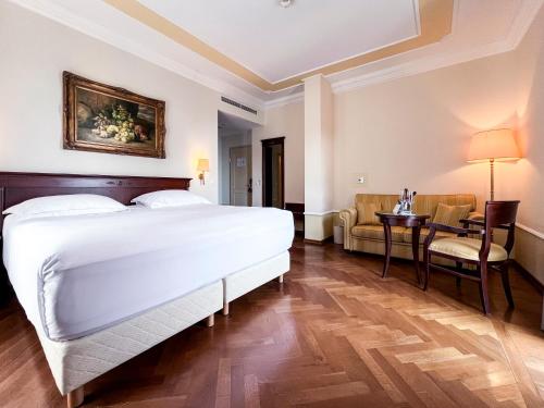 a bedroom with a bed and a table and a chair at Amadria Park Hotel Agava in Opatija