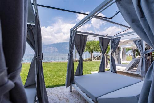 a bed in a tent with a view of the ocean at Ambienthotel PrimaLuna 3S in Malcesine