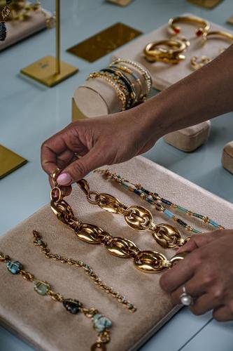 a woman is making a chain in a store at Cowley Manor Experimental in Cheltenham
