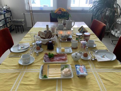ハノーファーにあるPrivatzimmer Wagnerの黄色いテーブル布の上に食べ物をかけたテーブル