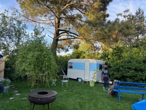 a woman standing next to a trailer in a yard at La Caraval in Saint-Pierre-des-Corps