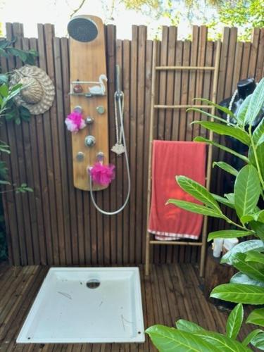 une douche sur une clôture en bois avec une serviette rouge dans l'établissement La Caraval, à Saint-Pierre-des-Corps
