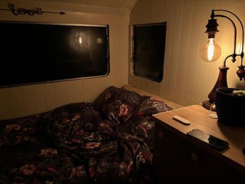 a room with a couch and a table with a lamp at La Caraval in Saint-Pierre-des-Corps