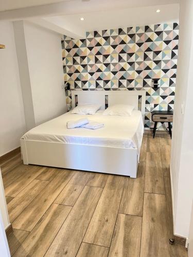 - une chambre avec un lit blanc et du parquet dans l'établissement • Le soleil du Panier • Coeur historique, à Marseille