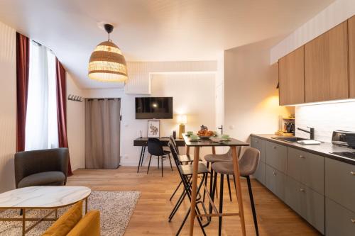 une cuisine et un salon avec une table et des chaises dans l'établissement La Belle Edith - Appt au cœur de Rennes, à Rennes