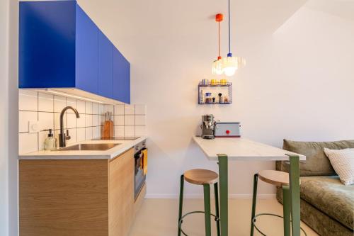a kitchen with blue cabinets and a sink and a couch at Les Baigneurs - Gigaro- Plage à 300m in La Croix-Valmer