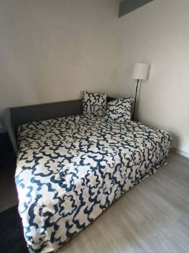 une chambre avec un lit avec une couette bleue et blanche dans l'établissement Studio équipé terrasse et jardin, à Vielle-Saint-Girons