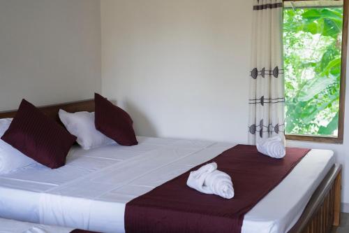a bedroom with a large bed with towels on it at River paradise safari house with cooking class in Udawalawe