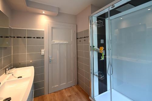 ein Badezimmer mit Glasdusche und Waschbecken in der Unterkunft Le Cocoon Clairefontaine - Maison vue montagne in Cornimont