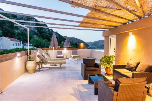 a patio with couches and chairs on a roof at Luxury apartment with rooftop pool in Meronas in Méronas