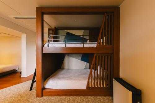 two bunk beds in a room with a staircase at Hotel Vison in Taki