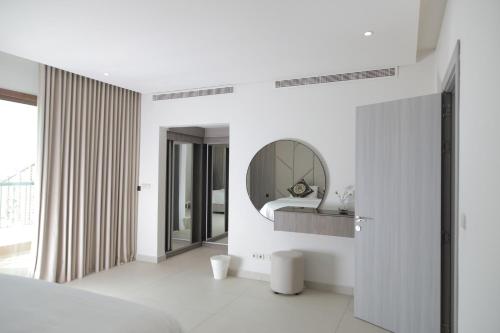 a white bathroom with a sink and a mirror at Durrat Al Arous - Rose Beach Villas in Durat  Alarous