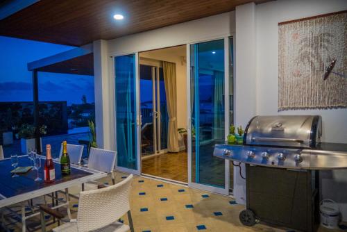 a kitchen with a counter and a table with chairs at Celebrity Ocean View Villa Samui in Bang Rak Beach