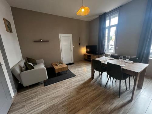 un salon avec une table, des chaises et un canapé dans l'établissement Grand appartement avec jardin - Centre ville, à Cambrai