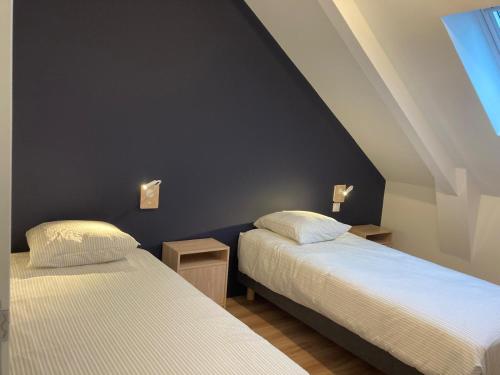 deux lits côte à côte dans une pièce dans l'établissement Grands appartements face au port, à Quiberon