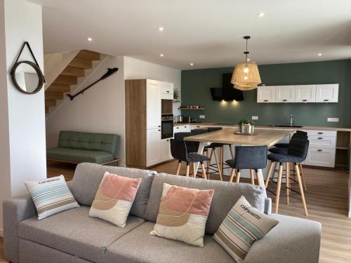 un salon et une cuisine avec un canapé et une table dans l'établissement Grands appartements face au port, à Quiberon