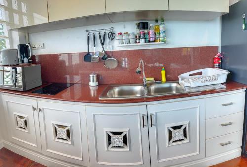 a kitchen with white cabinets and a sink at Celebrity Ocean View Villa Samui in Bang Rak Beach