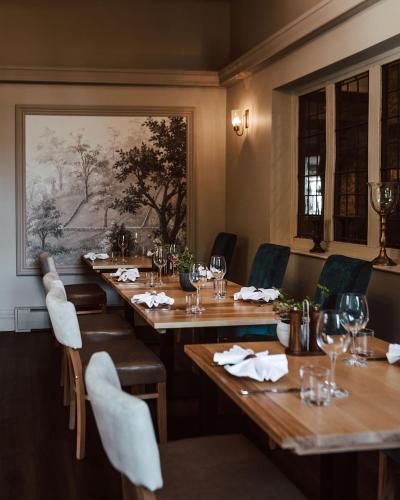 a restaurant with wooden tables and chairs and a painting at Weston Hall Hotel Sure Hotel Collection by Best Western in Bulkington