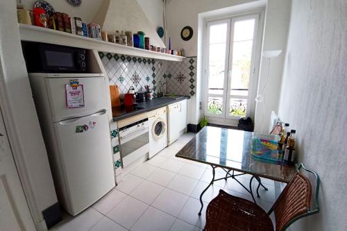 une petite cuisine avec une table et un réfrigérateur dans l'établissement Spacious T2 near the historic sites of Nice, à Nice