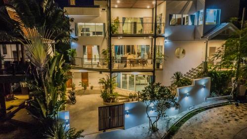 an apartment building with a swimming pool and palm trees at Celebrity Ocean View Villa Samui in Bang Rak Beach