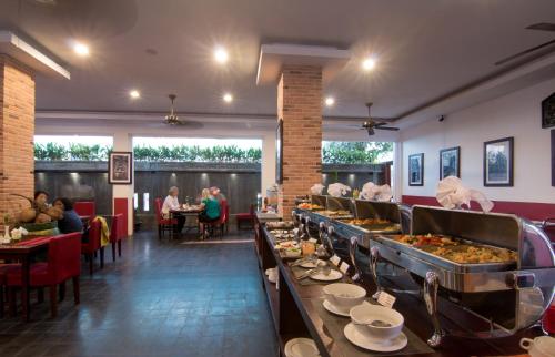 a buffet line with people sitting at tables in a restaurant at Mekong Angkor Palace Hotel in Siem Reap