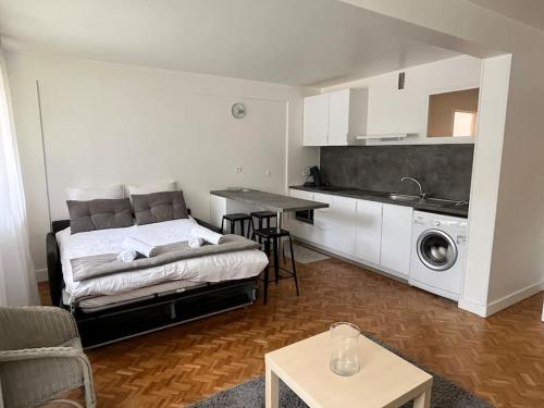 un salon avec un lit et une cuisine dans l'établissement Harmonie - Affaires & Loisirs à Rueil, à Rueil-Malmaison