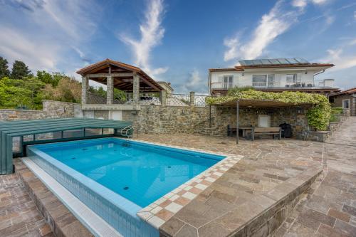 a swimming pool in front of a house at Debeli Rtič Apartments in Ankaran