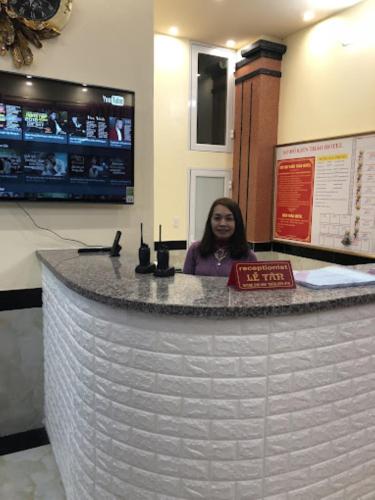 a woman sitting at a counter in a room at Kien Thao Hotel in Ha Giang