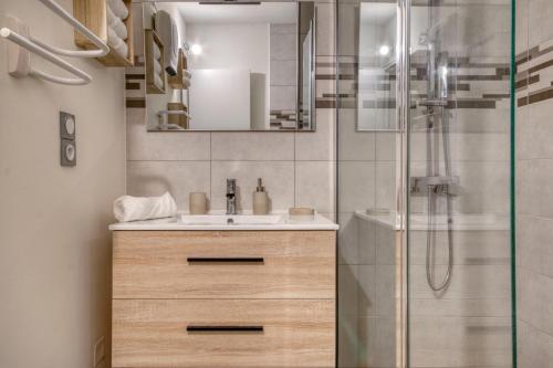 une salle de bain avec un lavabo et une douche dans l'établissement Le Cocon de Port-Louis - Appt à 200m de la plage, à Port-Louis