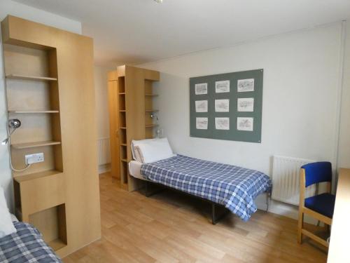a small room with a bed and a book shelf at Friendship House (Southwark) in London