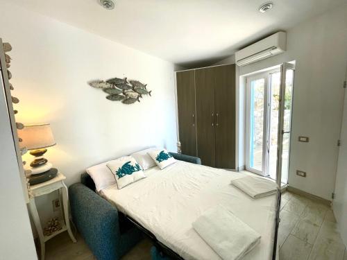 a small bedroom with a bed and a window at Come stare sulla prua di una barca! in Giglio Porto
