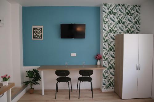 a blue wall in a room with a table and two stools at LP - Planet in Annecy