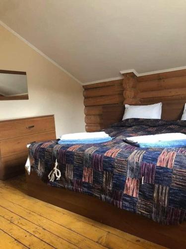 a bedroom with a large bed and a wooden floor at Золото Карпат in Izki