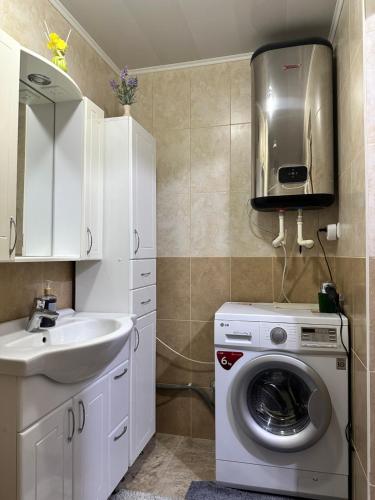 Un baño con lavadora y lavabo. en Modern Apartment - Calm Location - Boat in the Yard, en Chişinău