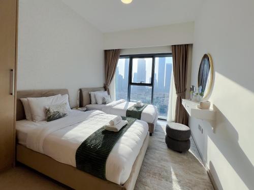 two beds in a hotel room with a window at 2BR Stunning Full Burj Khalifa View in Dubai