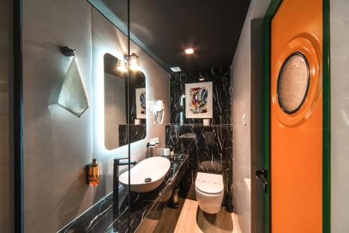 a bathroom with a sink and two toilets in it at Hotel Kerber in Podgorica