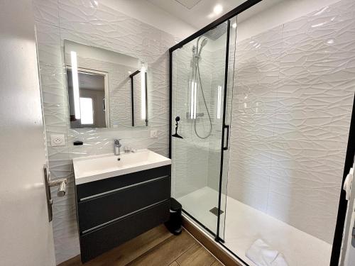 une salle de bain blanche avec un lavabo et une douche dans l'établissement • Le soleil du Panier • Coeur historique, à Marseille