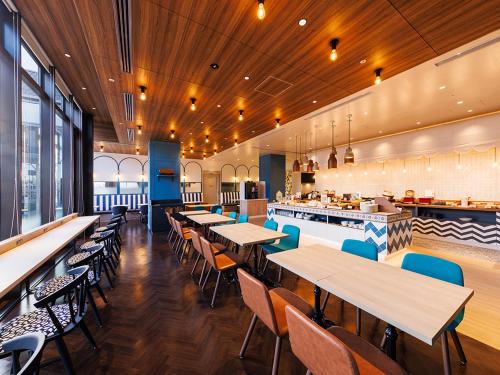a restaurant with wooden ceilings and tables and chairs at JR East Hotel Mets Premier Makuhari Toyosuna in Chiba