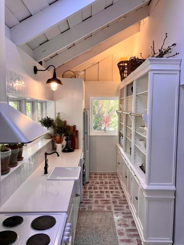 a kitchen with white counters and a stove top oven at Cosy, romantic, private cottage, close to all & pet friendly in Healesville