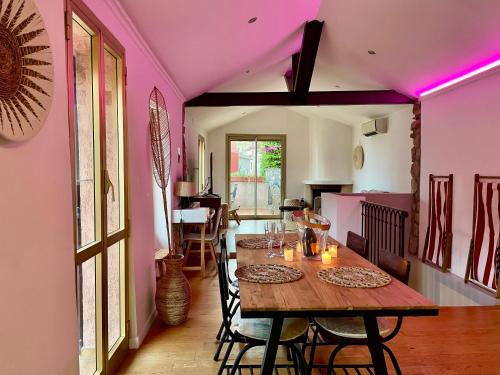 une salle à manger avec des murs roses et une table en bois dans l'établissement Renovated House In The Center Of Beausoleil, à Beausoleil