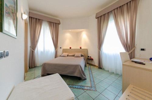 a bedroom with a bed and two large windows at Pietra di Luna residence in Maiori