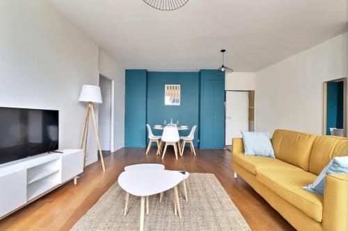 un salon avec un canapé jaune et une table dans l'établissement Le St Georges - Charming & Spacious flat - Lyon 5th, à Lyon