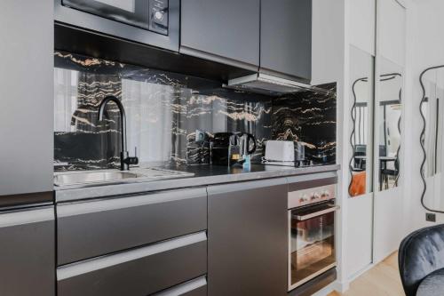 une cuisine avec un évier et une cuisinière dans l'établissement Elegant apartment - 1BD-2P - Panthéon, à Paris