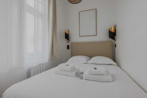 une chambre avec un lit blanc avec des serviettes dessus dans l'établissement Elegant apartment - 1BD-2P - Panthéon, à Paris