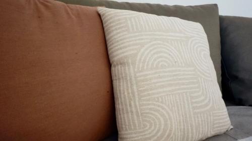 a woman sitting on a couch with a pillow at Lago 21 - Garden Terrace & Lake view in Pastrengo