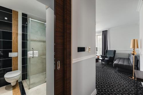 a bathroom with a toilet and a shower in a room at Rewita Imperial in Sopot