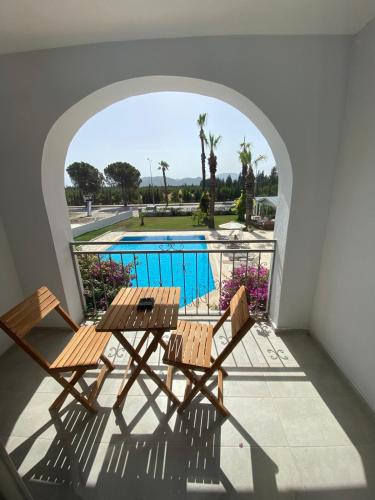 a balcony with two tables and a swimming pool at BURÇ HOTEL in Dalaman