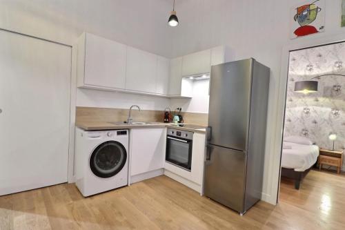 une cuisine avec un réfrigérateur et une machine à laver dans l'établissement Le Pêcherie - Beautiful & Modern apartment - Lyon 1st, à Lyon