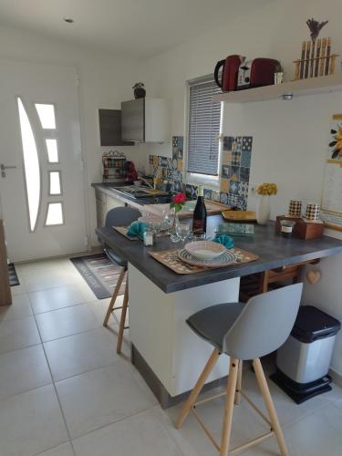 une cuisine avec un comptoir, une table et des chaises dans l'établissement Bienvenue au Dormidou en Provence !, à Vacqueyras